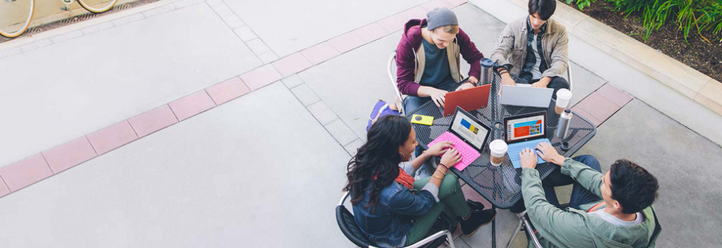 Vier Schüler nutzen Office 365 auf ihren Laptops Vier Schüler nutzen Office 365 auf ihren Laptops