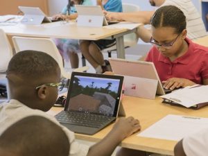 Zwei Kinder spielen im Unterricht Minecraft auf dem Laptop Zwei Kinder spielen im Unterricht Minecraft auf dem Laptop