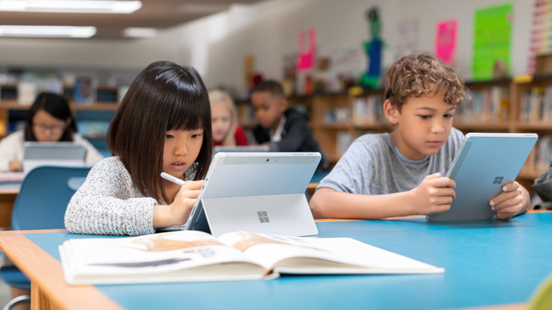 Auf dem Bild ist eine Schulklasse zu sehen. Alle Sch&uuml;ler arbeiten mit einem Surface-Ger&auml;t