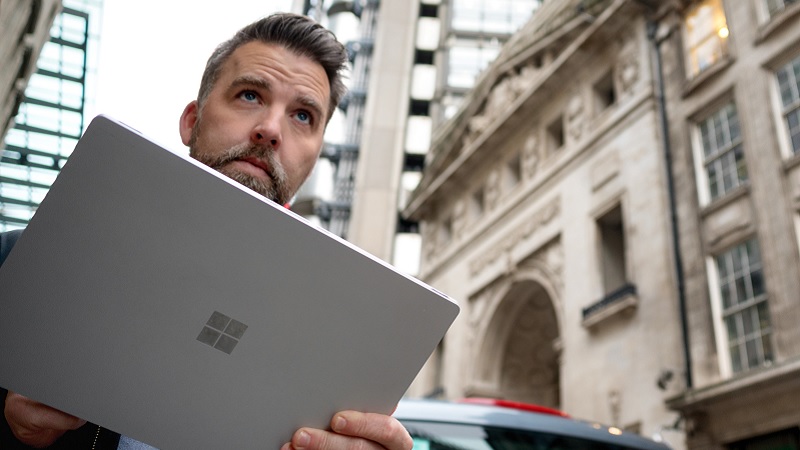 Ein Mann steht auf einer Star&szlig;e in London und h&auml;lt ein Surface Device in den H&auml;nden