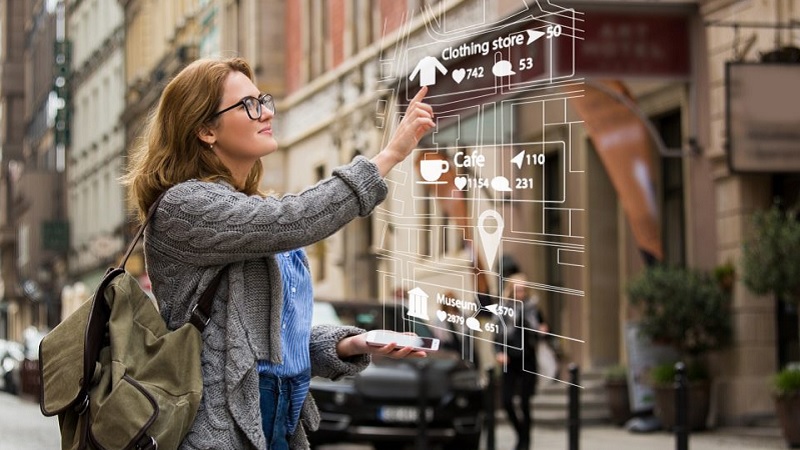 Eine Frau in einer Einkaufsstra&szlig;e arbeitet mit einem Hologramm