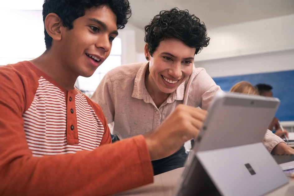 Eine Lehrerin zeigt einem Sch&uuml;ler etwas an seinem Tablet PC