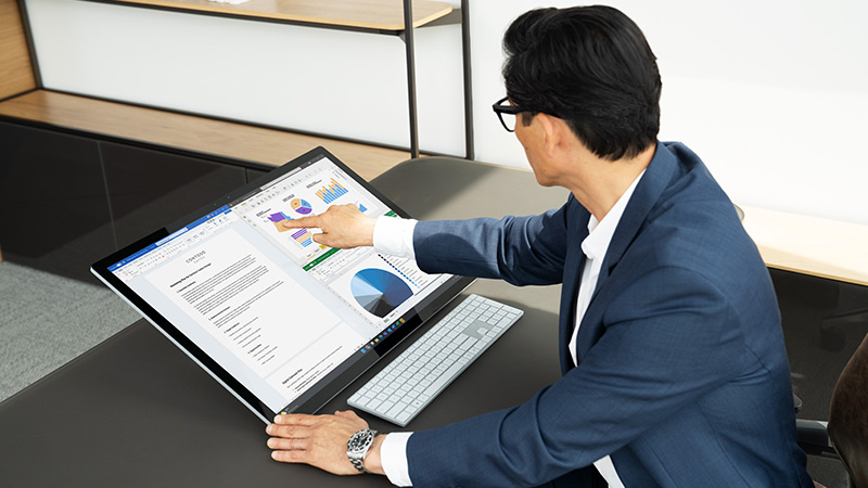 Mann auf Surface Studio und mit Power Apps