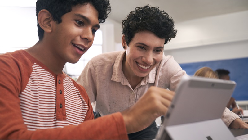 Zwei Sch&uuml;ler schauen gemeinsam auf einen Laptop