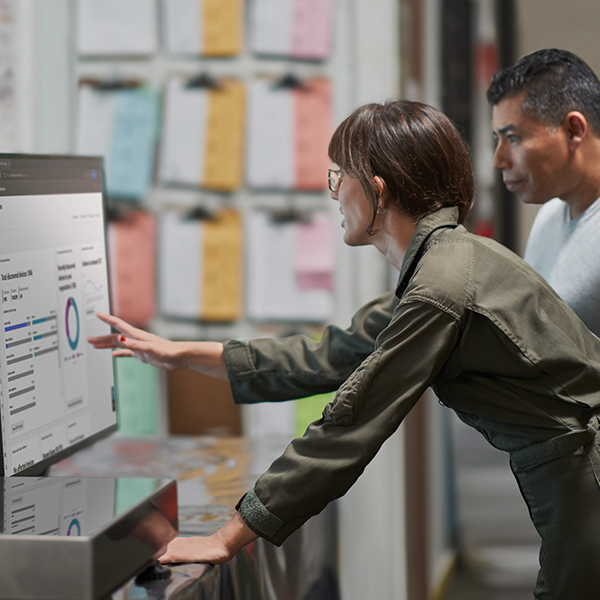 Two people reviewing an analytics report on a desktop computer.