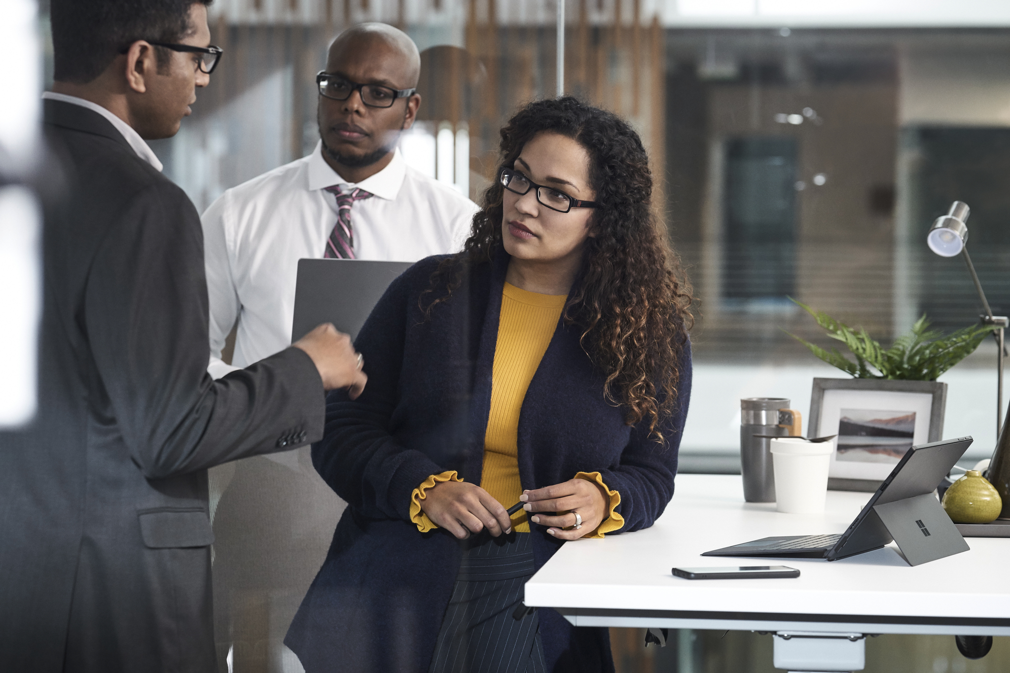 Three colleagues standing on an office in discussion