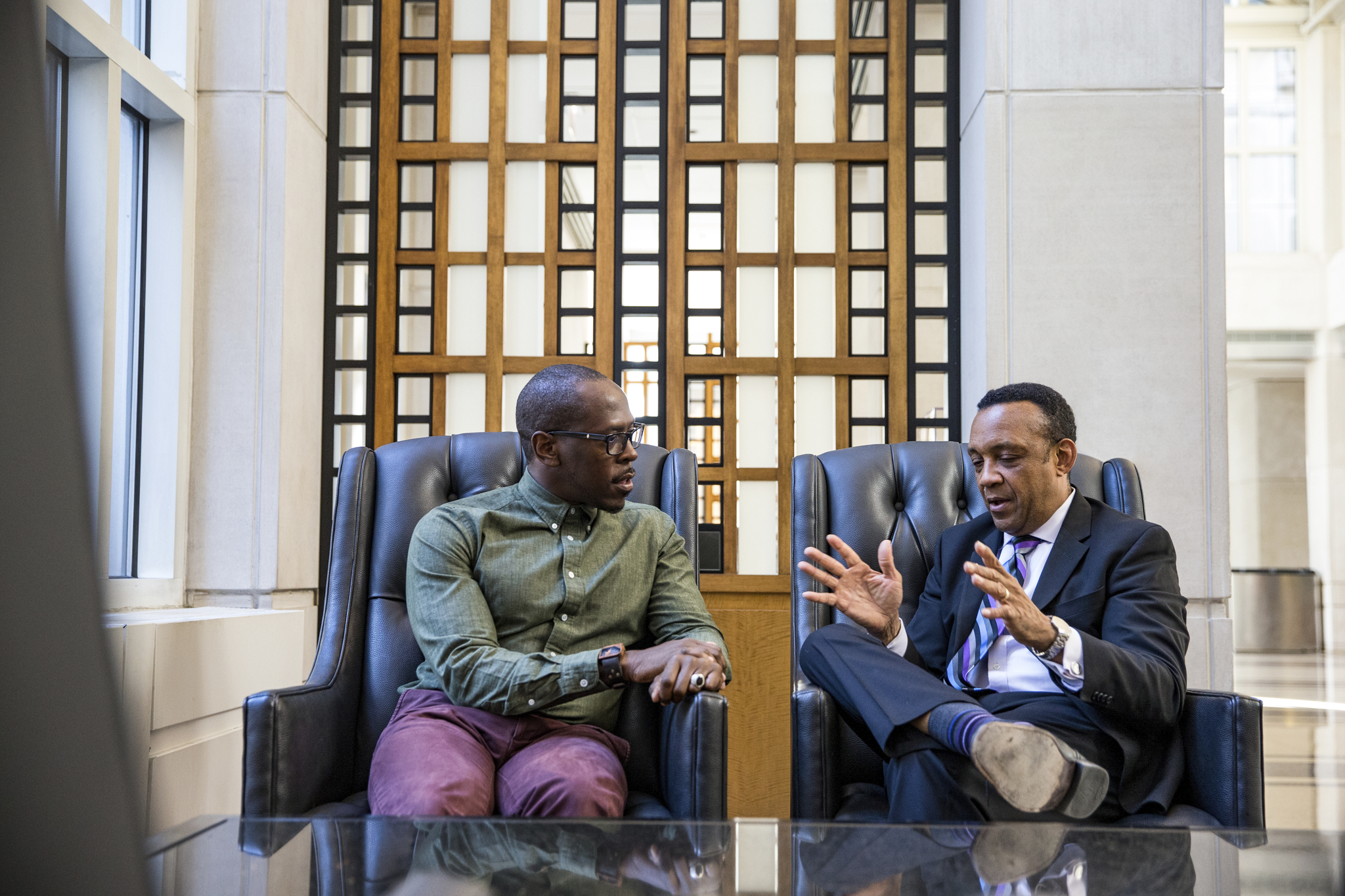 Two people sitting down talking to each other in a bright office setting