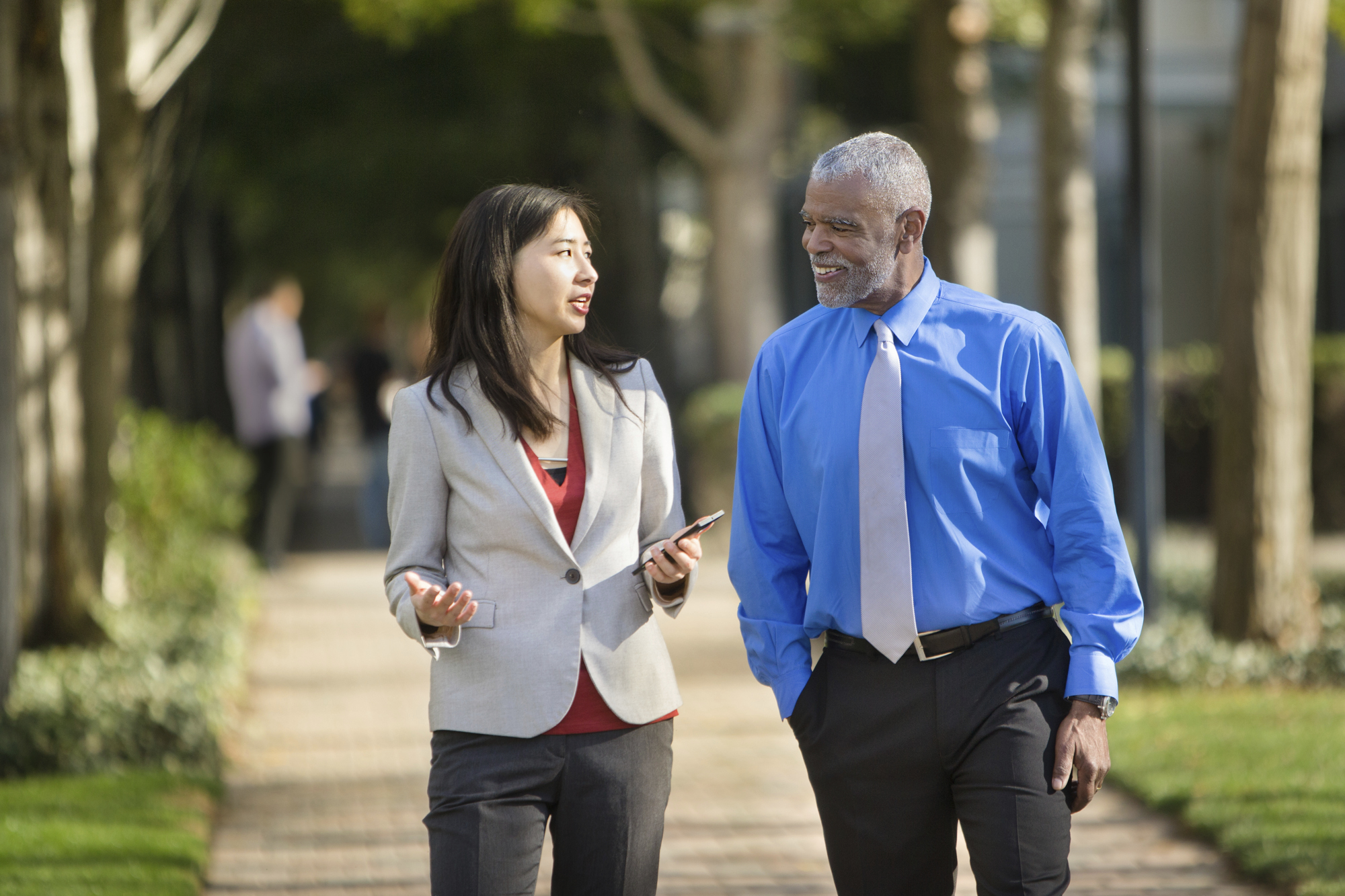Two business people walking and talking outdoors