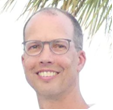 a person wearing glasses and smiling at the camera