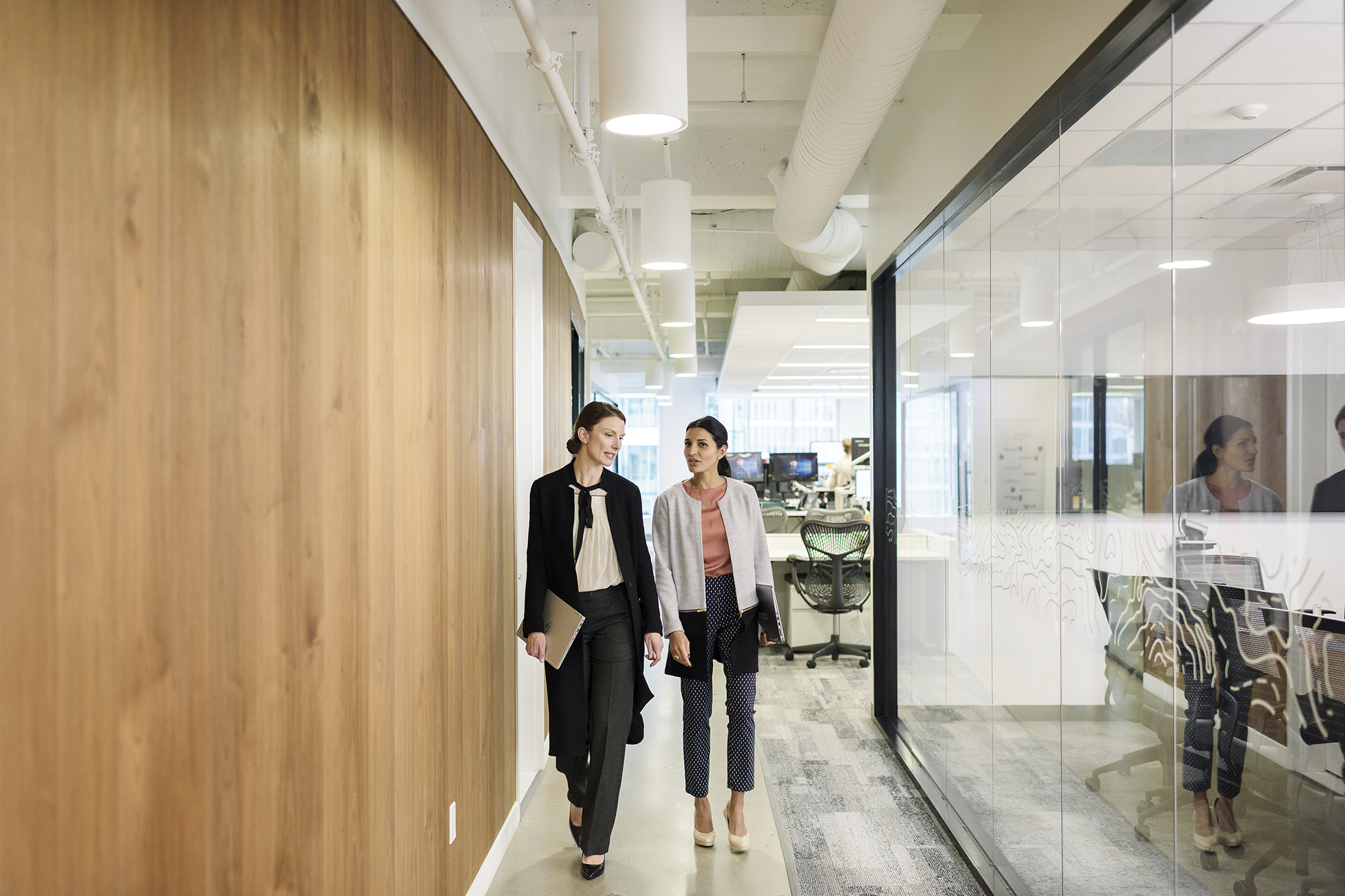 Two people walking down a hallway
