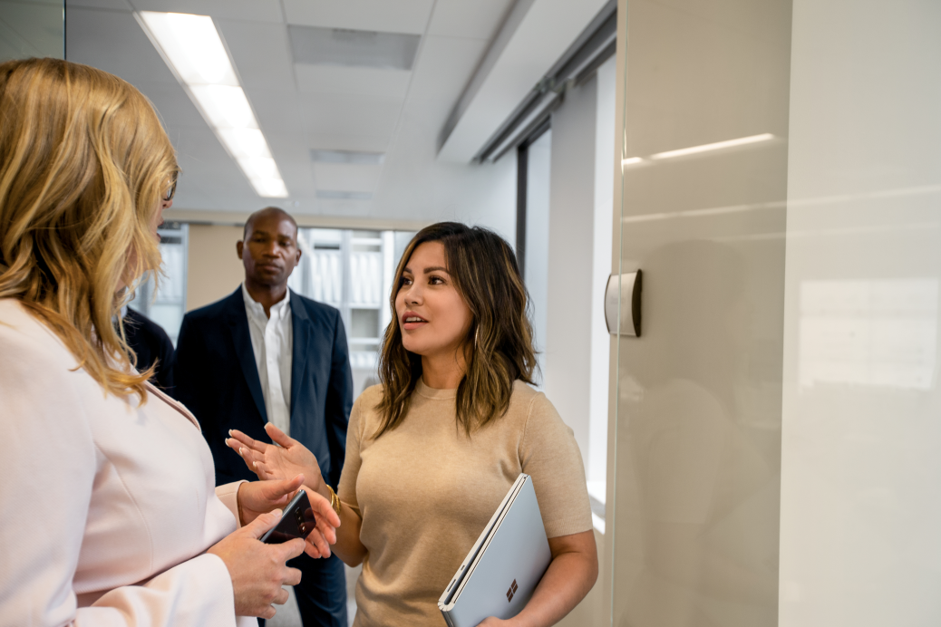 Two coworkers standing in the hallway