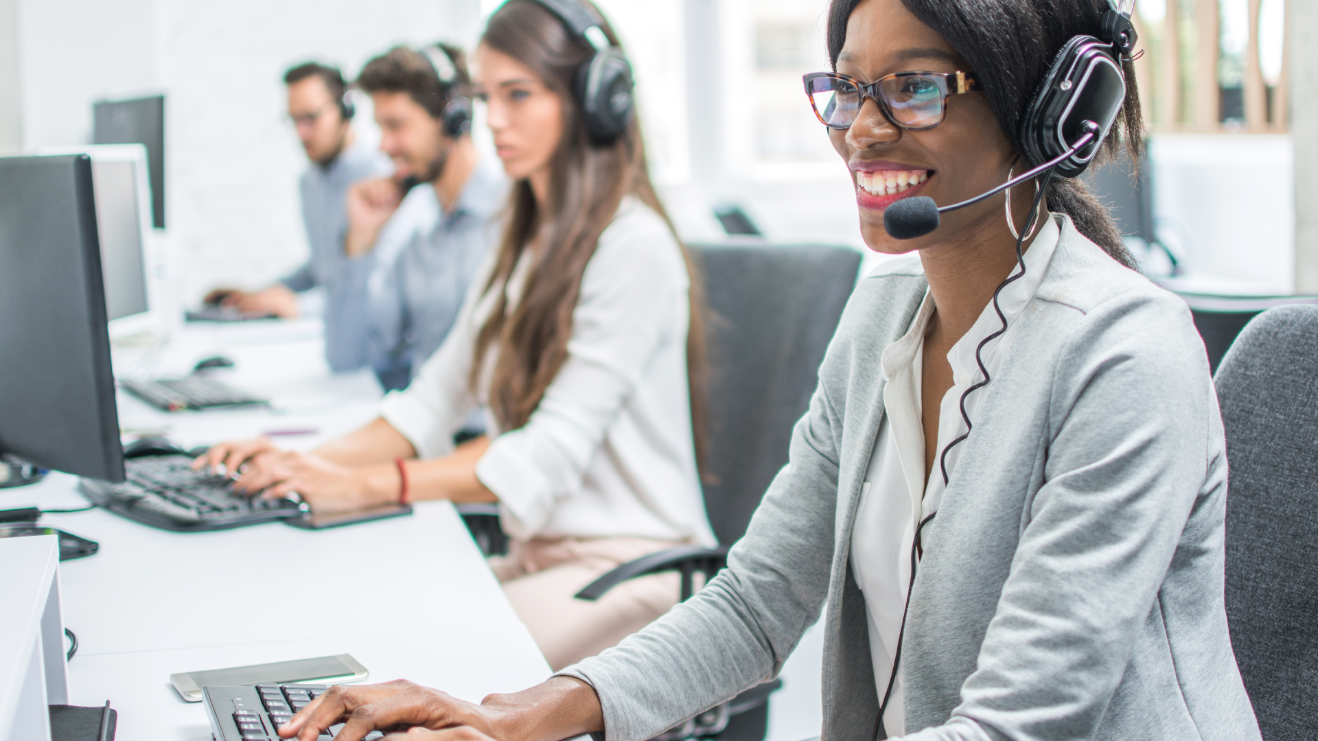 A group of customer service representatives with headsets on