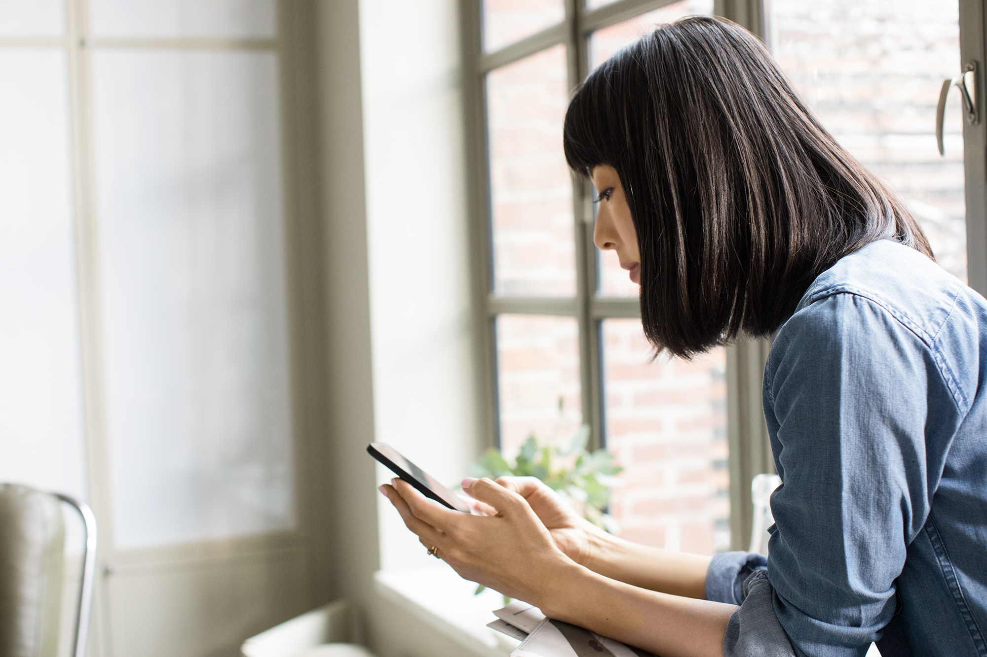 Female using phone in family room