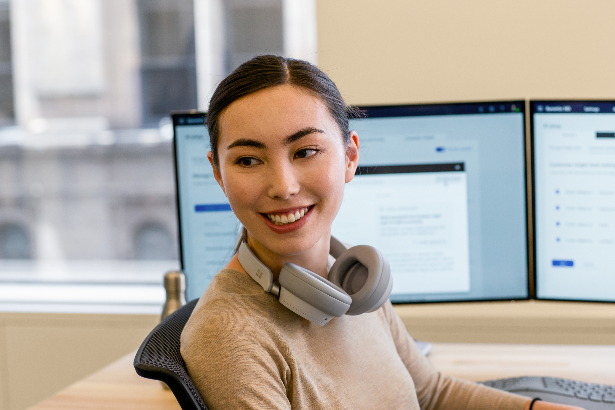 Engineer informal portrait. A female smiling with headphones around her neck