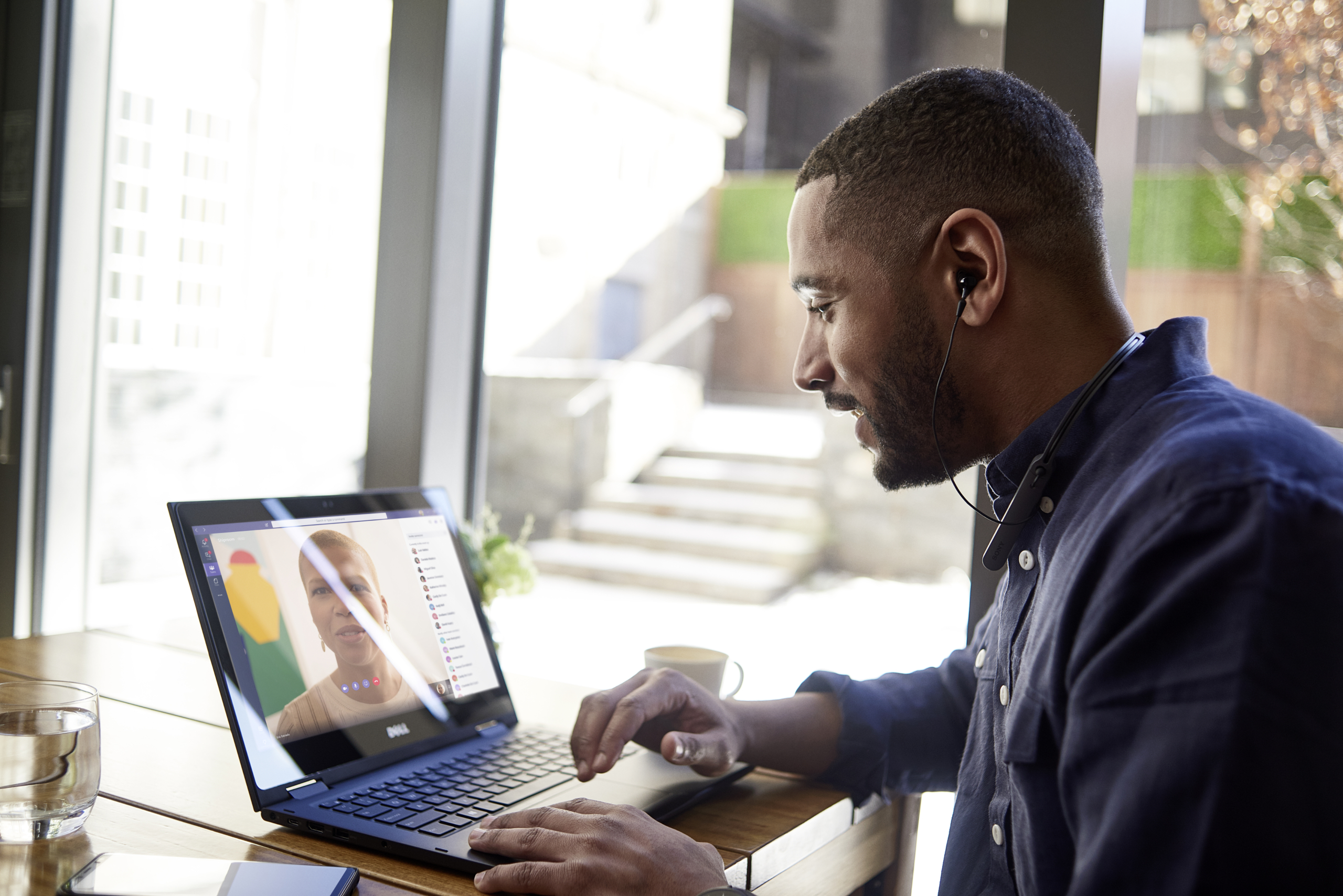 Male business professional at table using a Dell 3390 device that is running Microsoft Teams