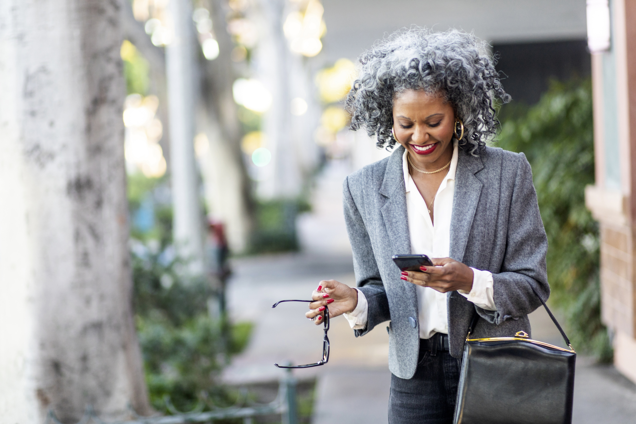 Woman Texting While Walking in City
