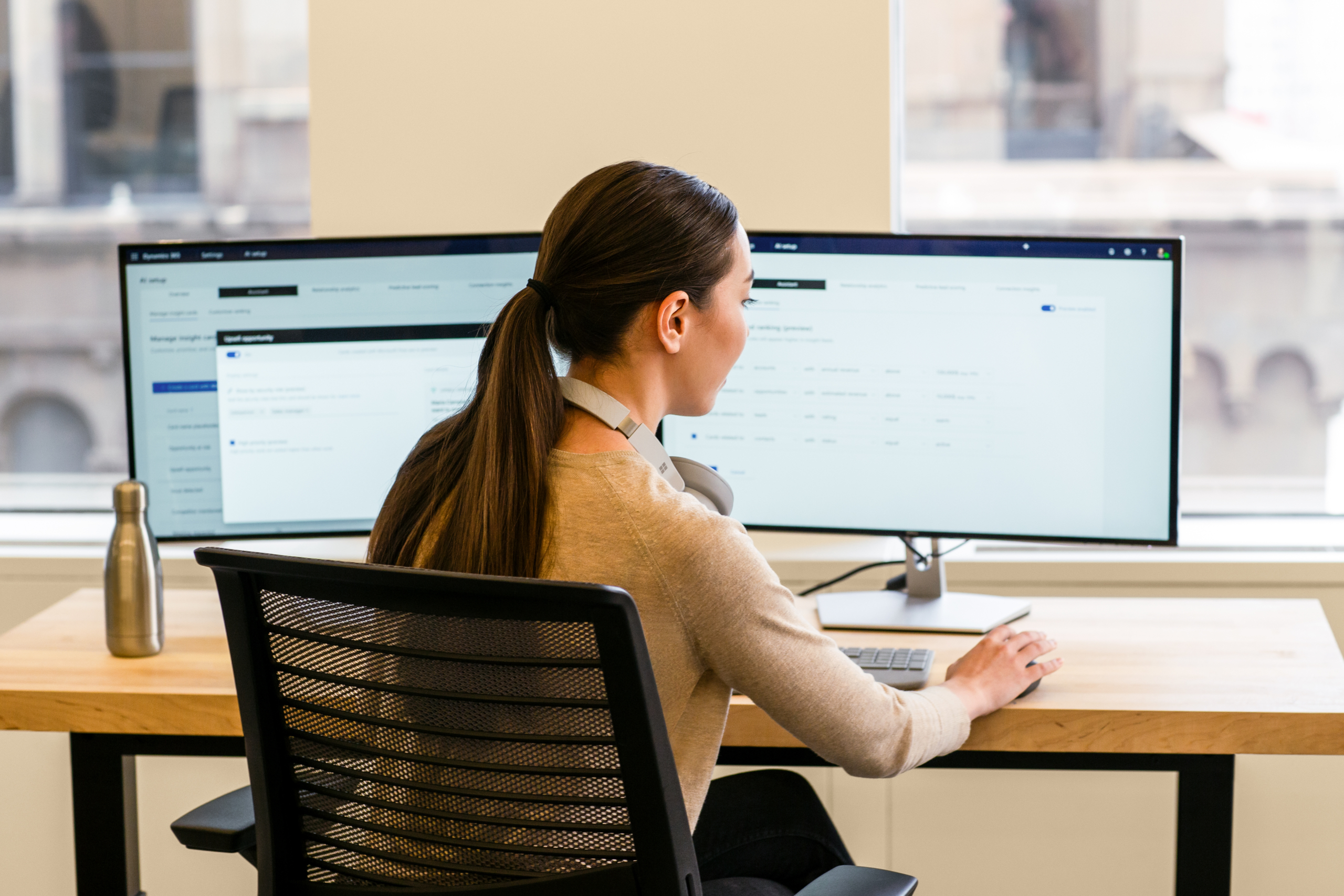 a person sitting at a desk in front of a laptop computer
