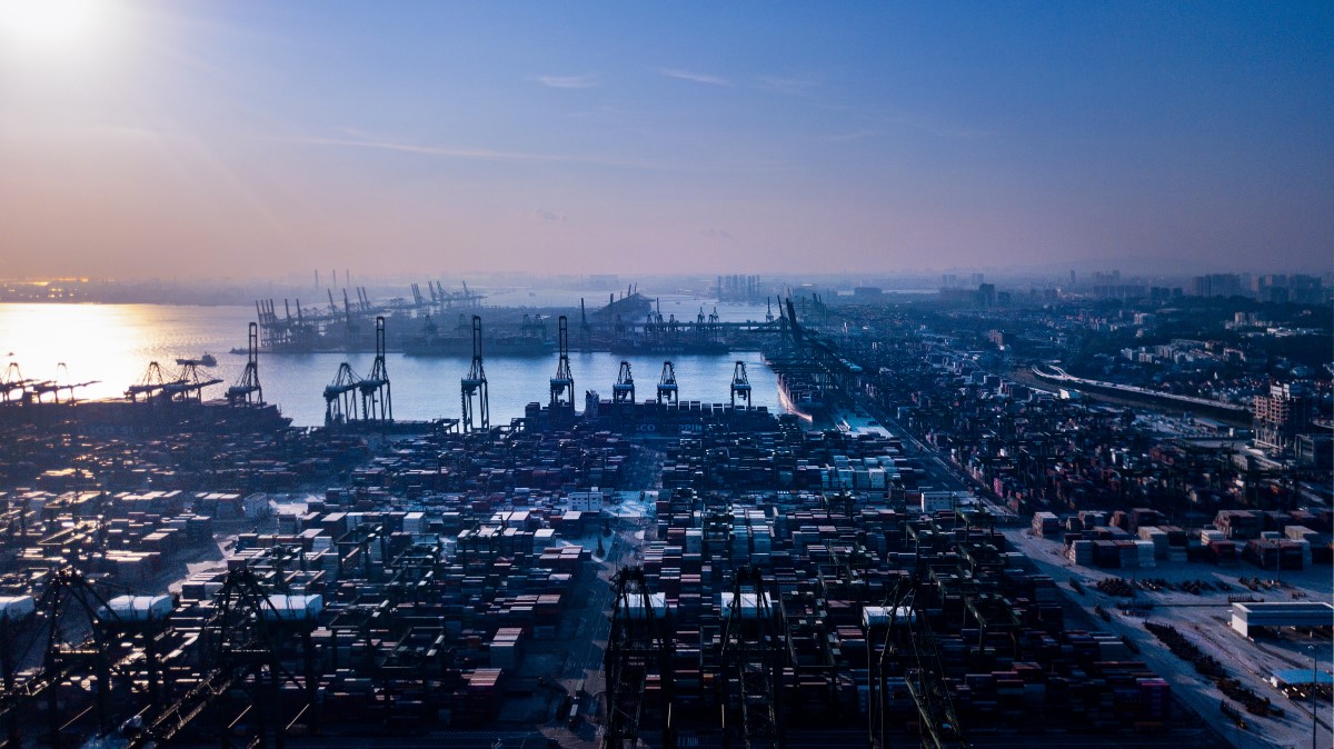 Aerial view of shipyard at Singapore port. Thousands of shipping containers are stacked near cranes lining the water