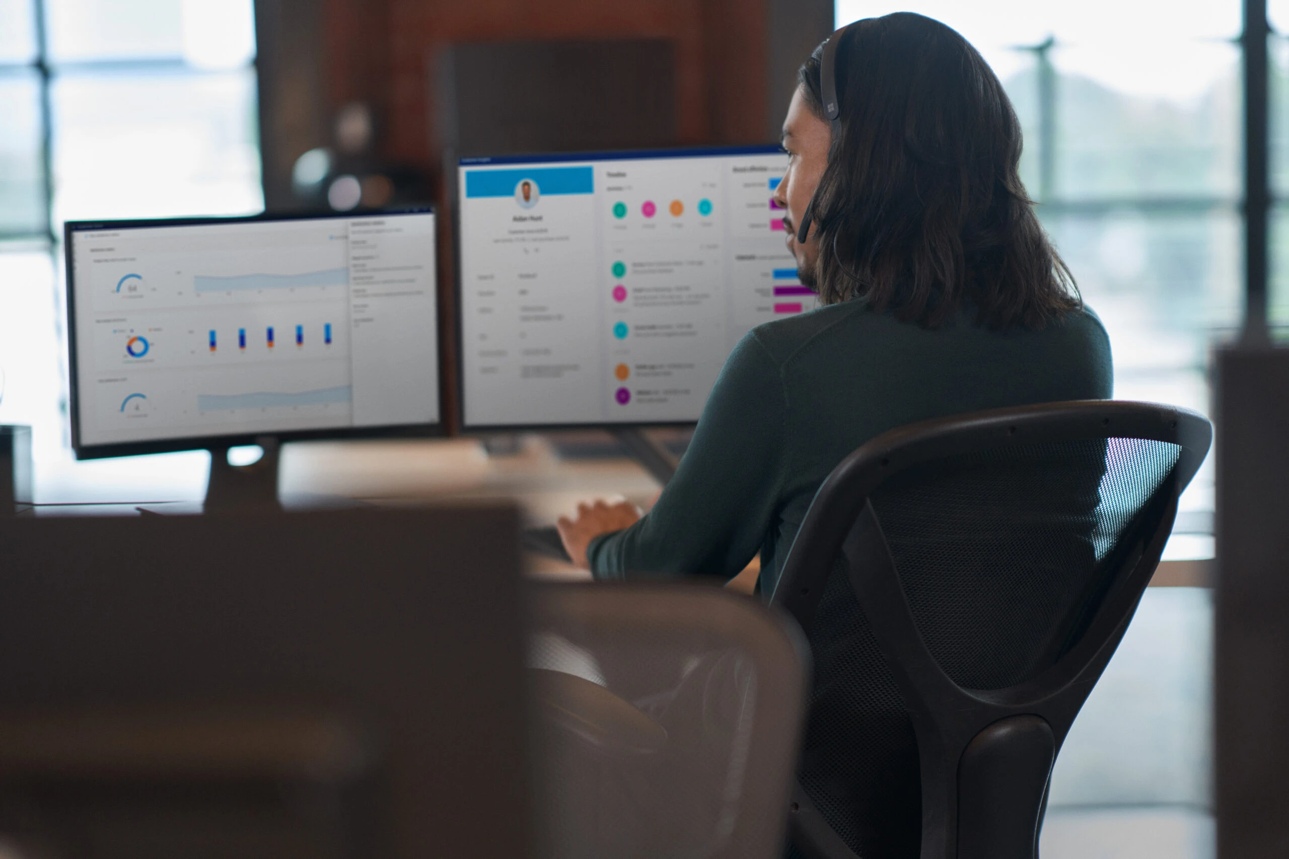 An agent looking at two monitors during a customer service call