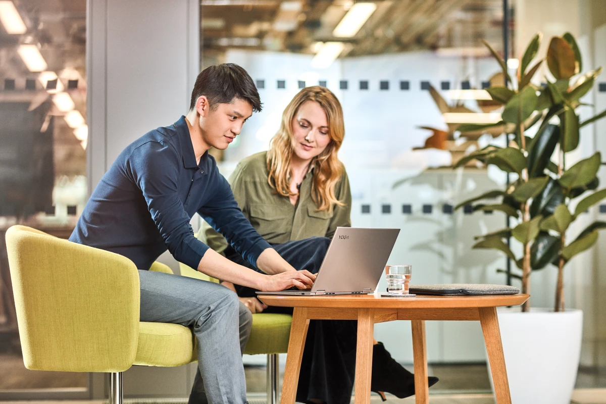 Man and women interacting with a Lenovo Yoga laptop