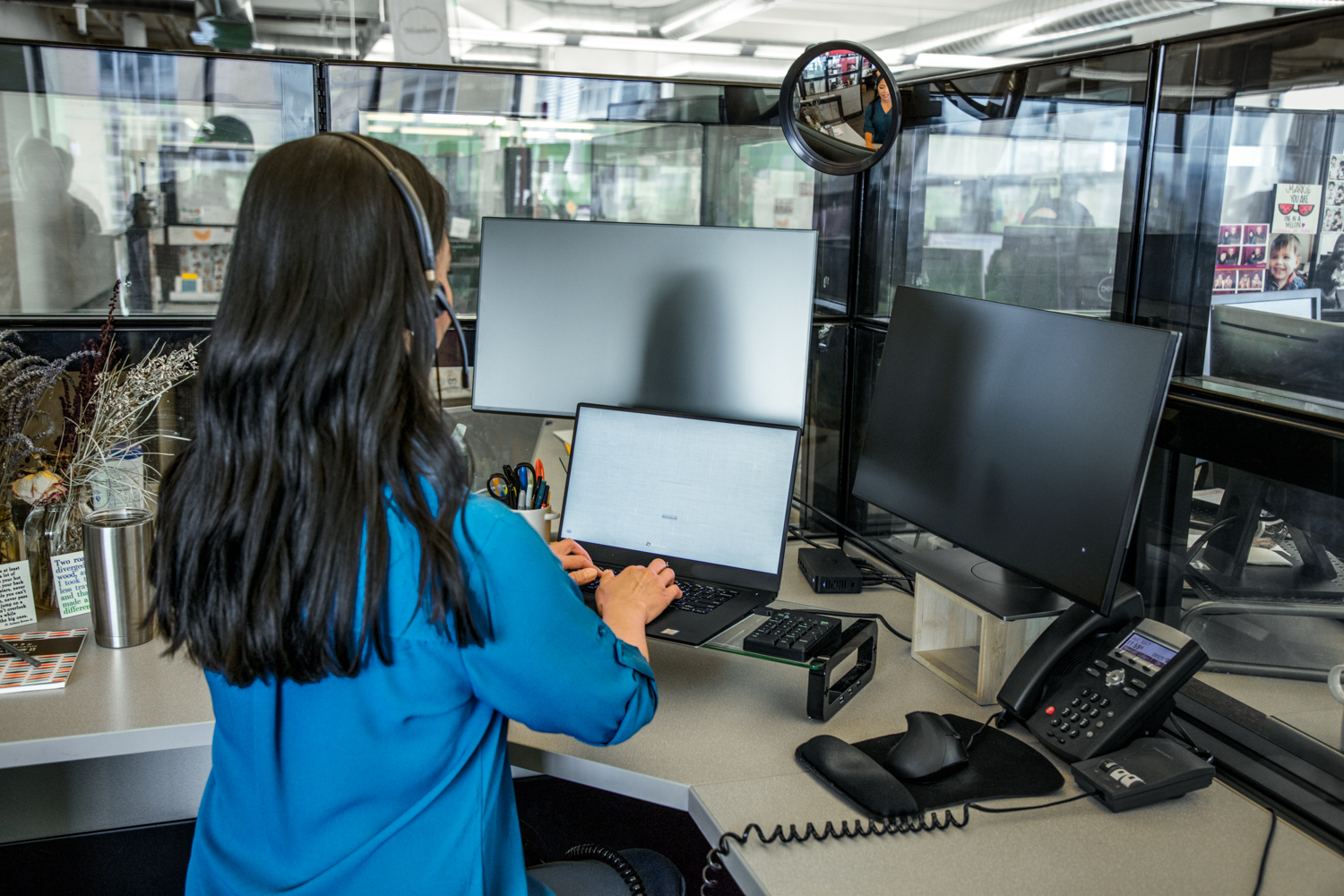 Photo of a female call center employee working at a standing desk