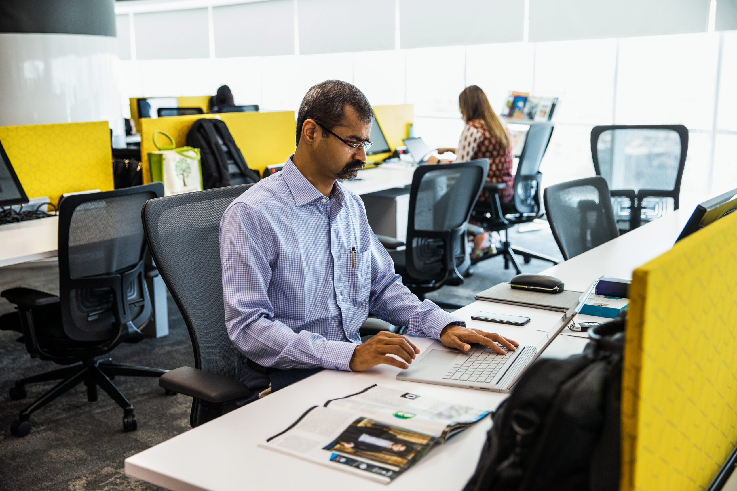 Photo of a man working on a laptop in a contact center