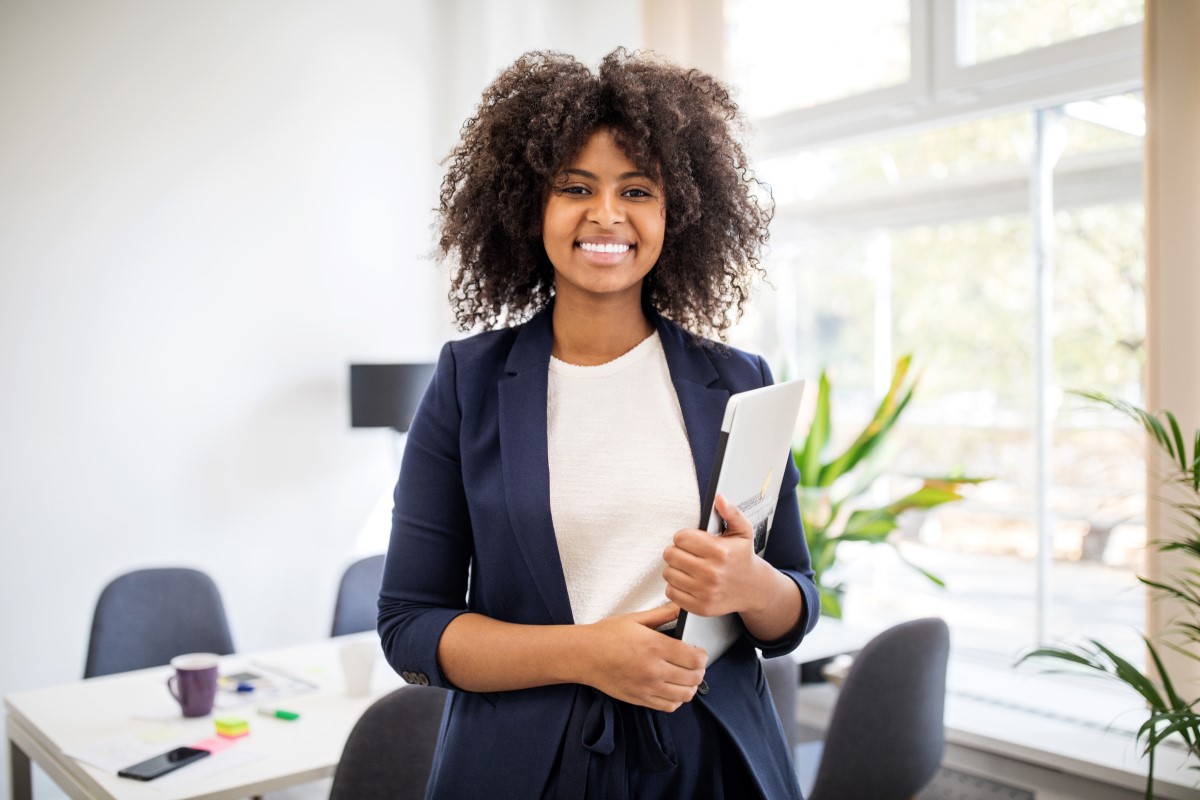 Young female professional at an office holding a laptop
