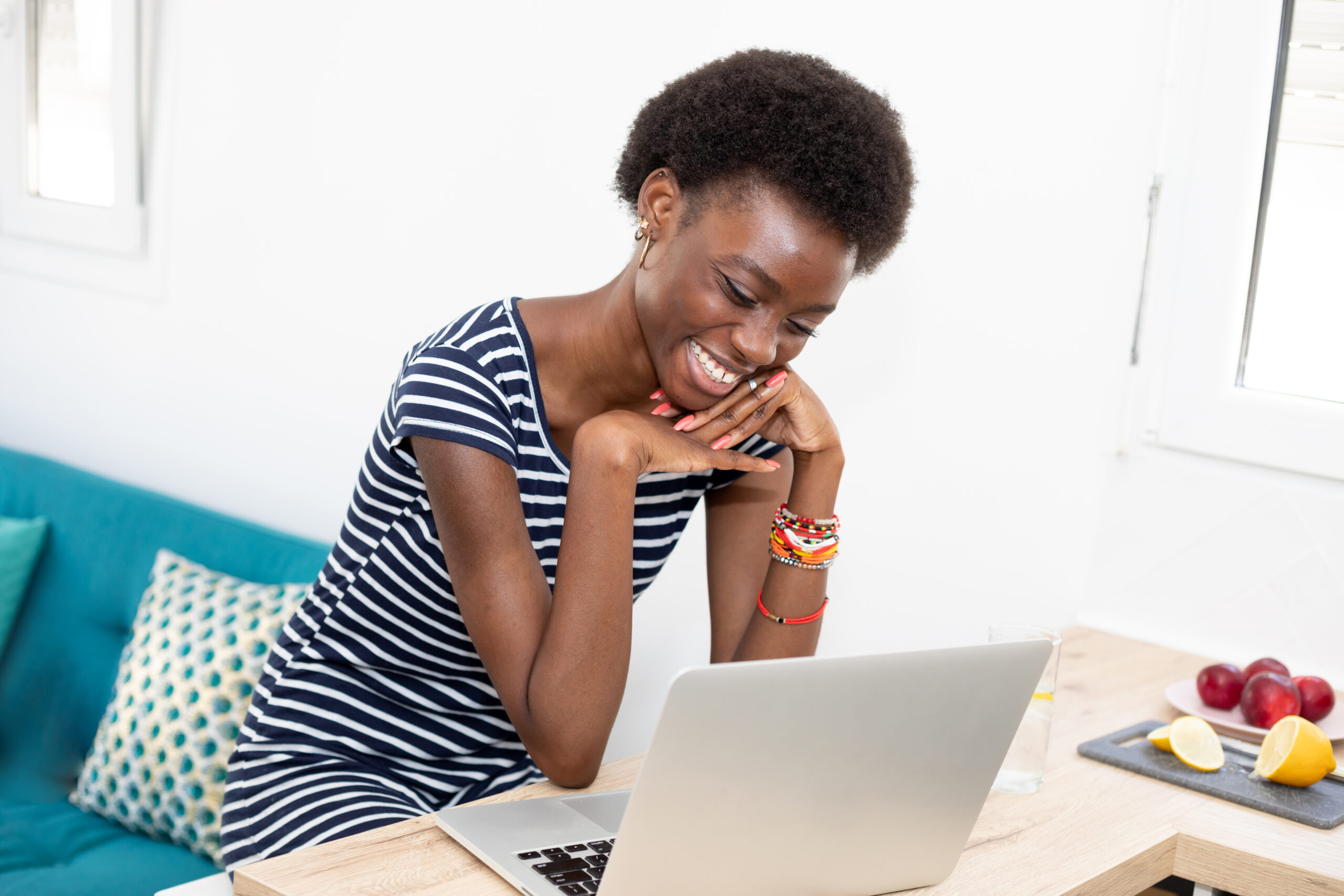 Photo of a young woman smiling at a laptop while reading a marketing email with personalized content
