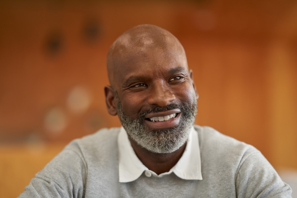 Close-up portrait of a man, smiling, looking past the camera