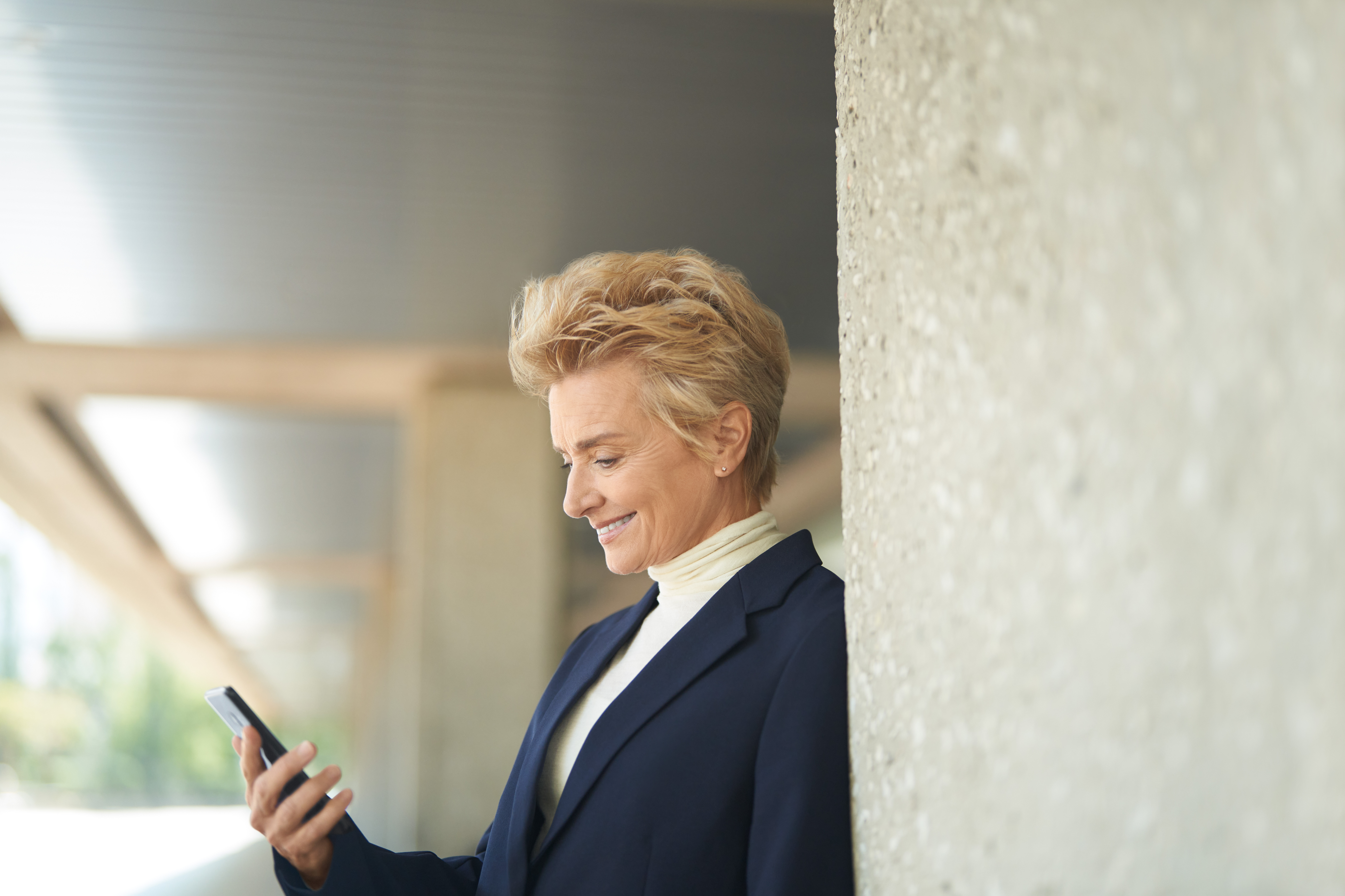 Photo of a happy customer looking at her cell phone on the go