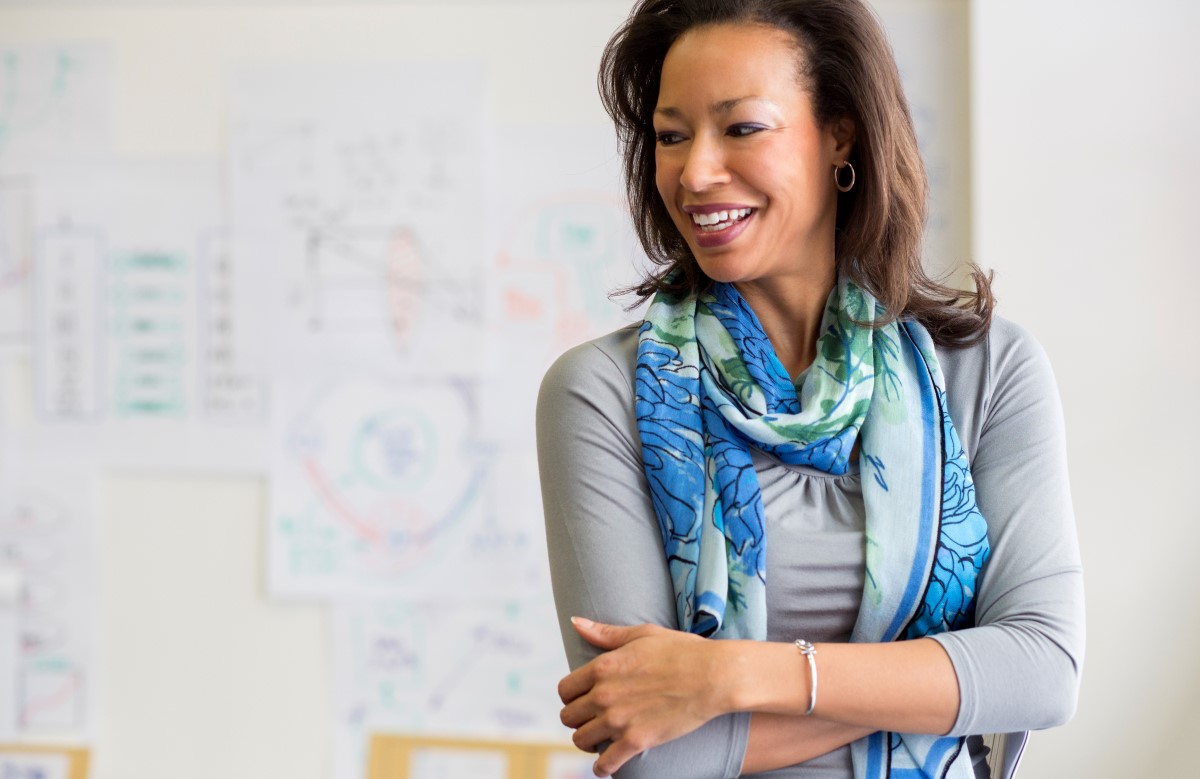 A businesswoman standing and smiling in boardroom