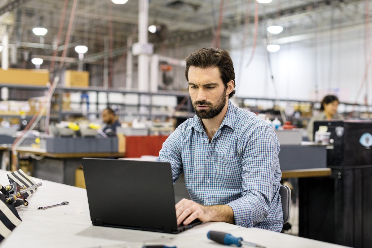 Man sitting at workstation in commercial manufacturing plant