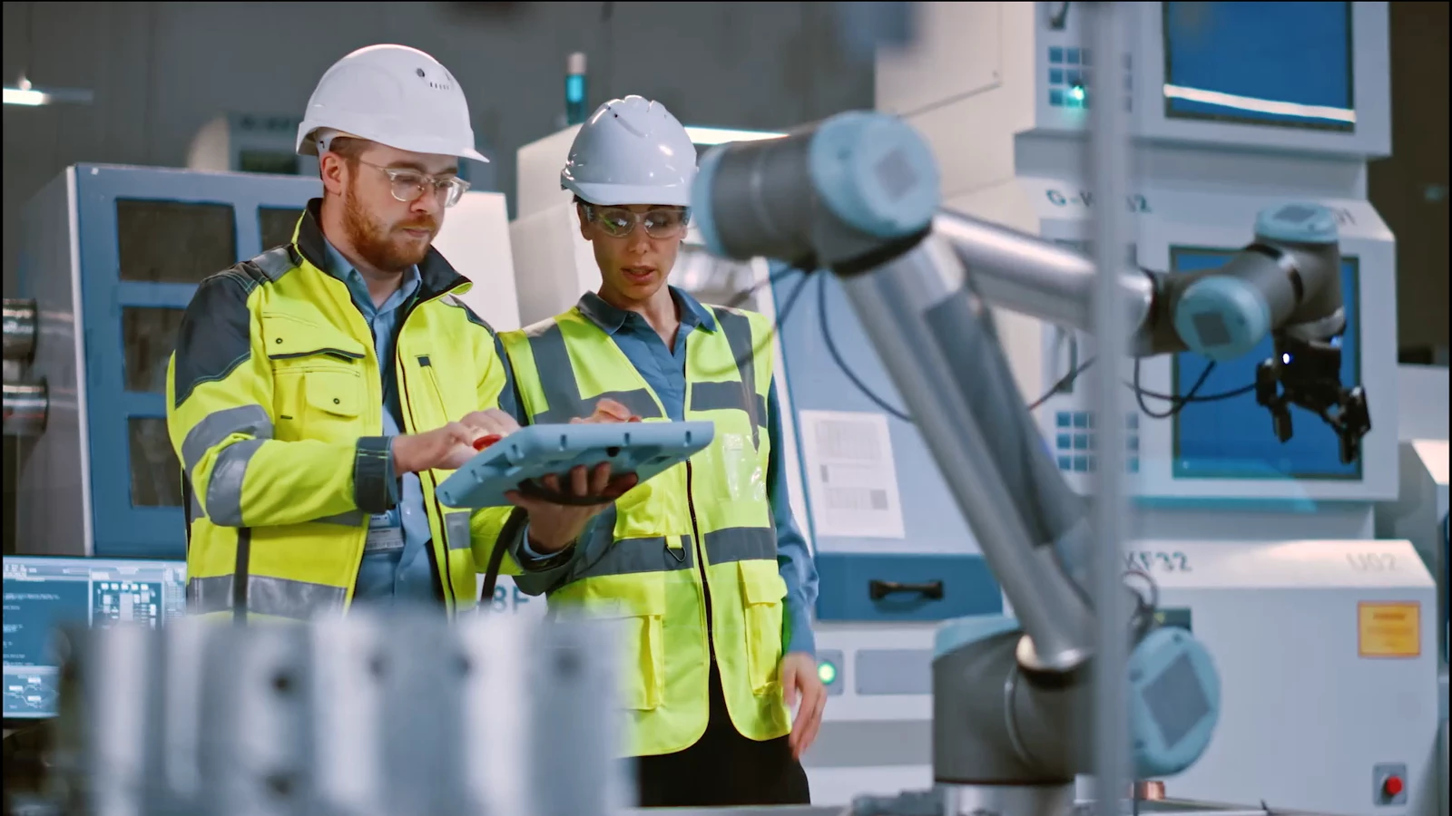 Two manufacturing professionals working on a tablet
