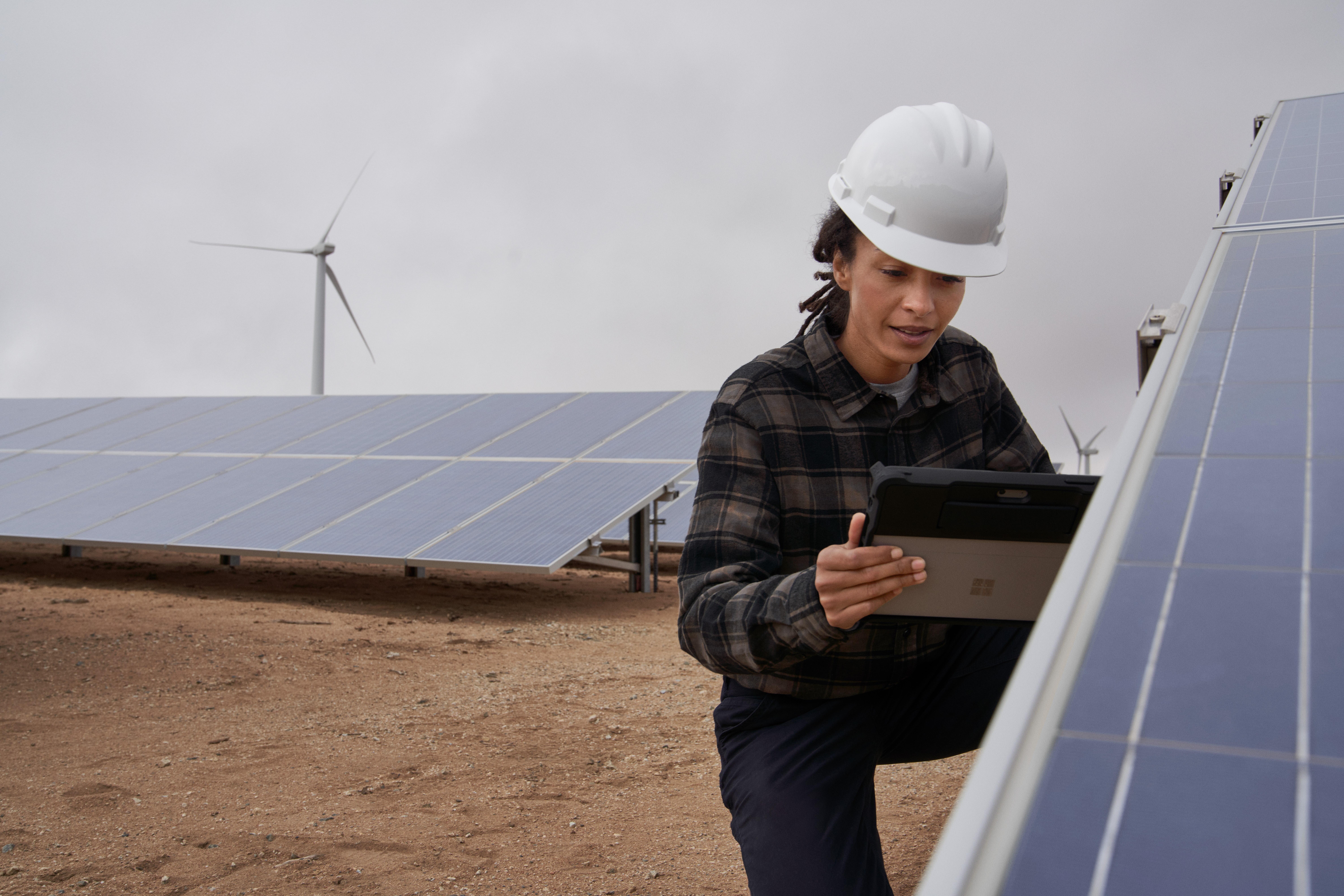 Photo of a field technician working on a solar panel farm
