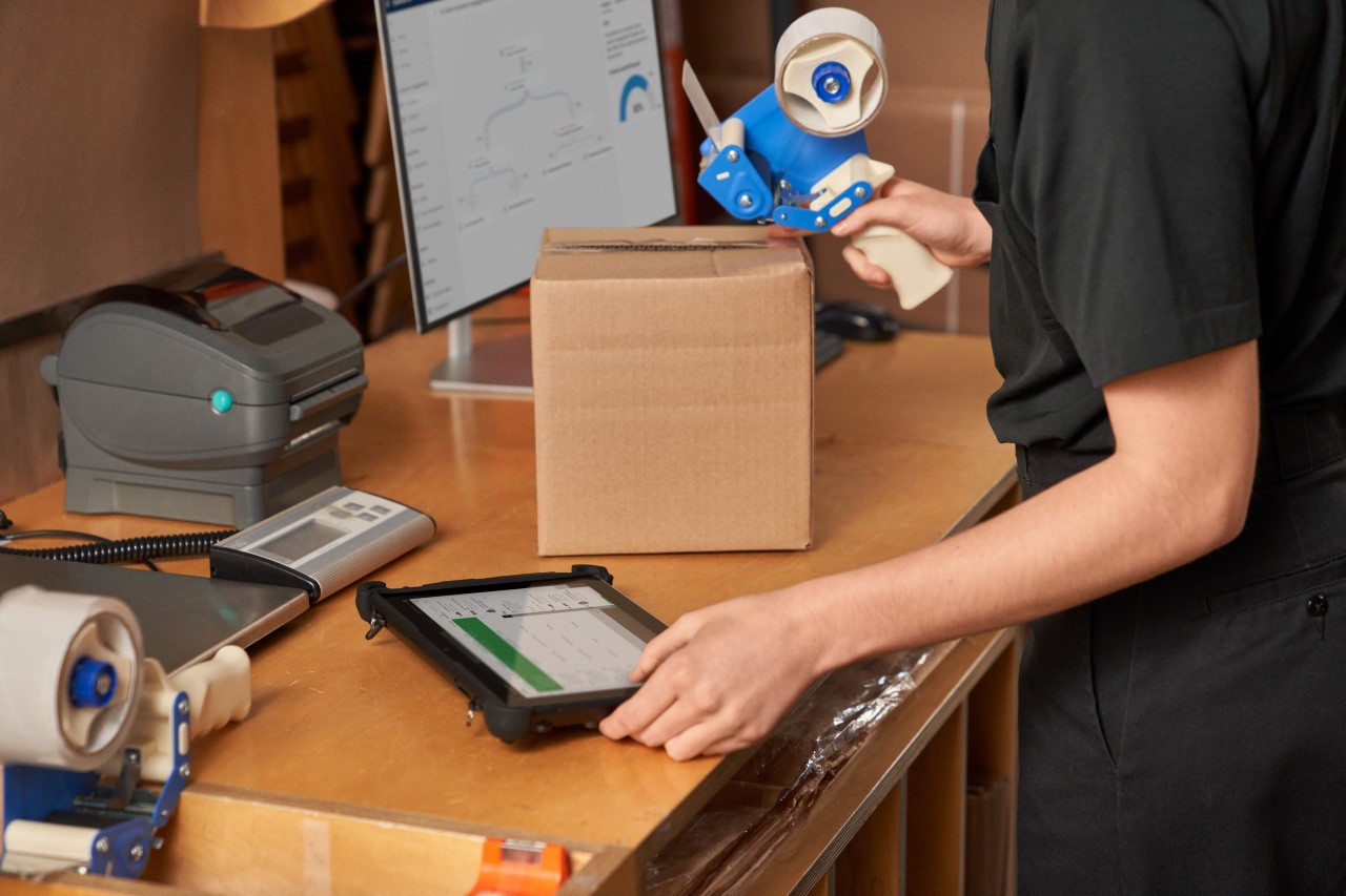 Customer service employee fulfilling, packaging and shipping online orders in the storeroom