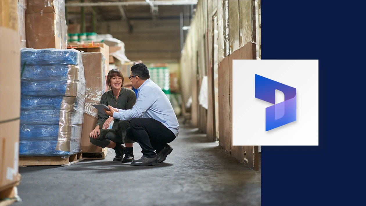 Two employees crouching down by boxes in a warehouse. The image incorporates the Dynamics 365 icon