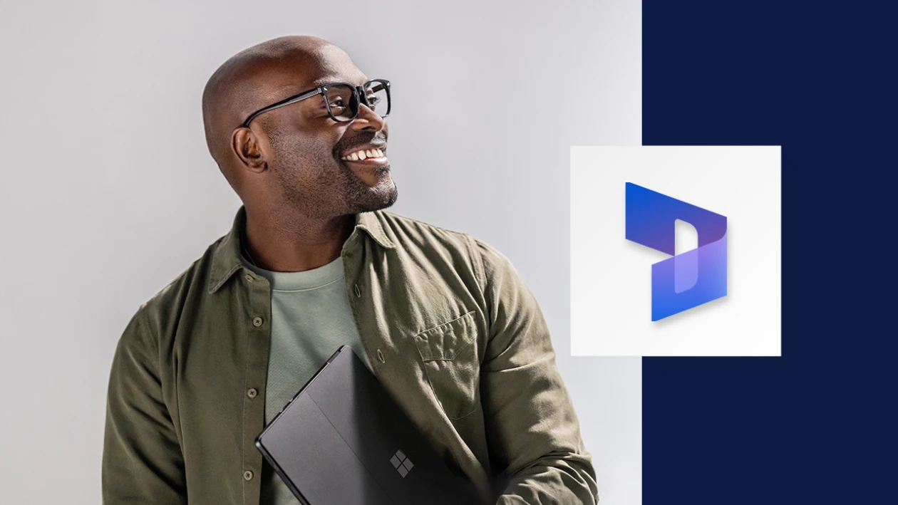 Portrait of smiling man carrying a Surface tablet. A wide, dark blue border runs down the right side of the image, overlaid with the Microsoft Dynamics 365 icon