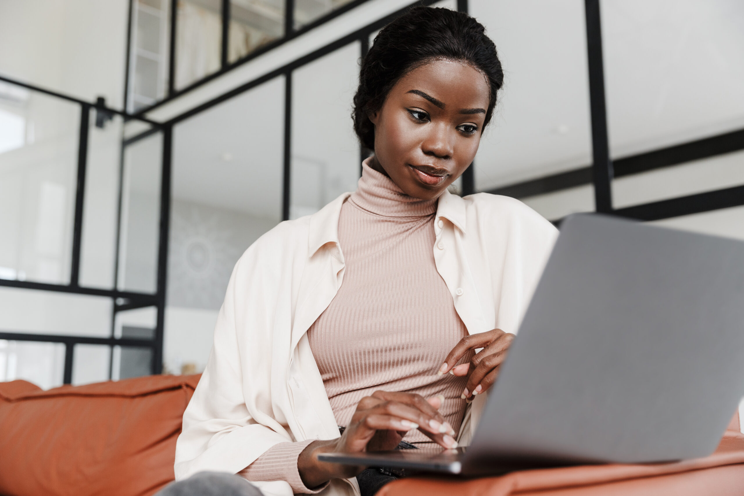 young smiling african woman reading email