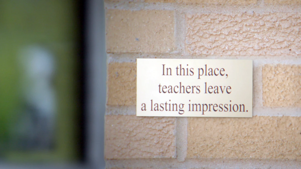 A plaque on a brick wall of a school that says, &ldquo;In this place, teachers leave a lasting impression.&rdquo;