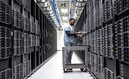 A man at work in an aisle of a datacenter