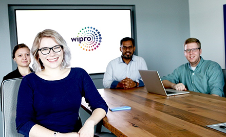 Image of a group of Wipro employees sitting around a conference table