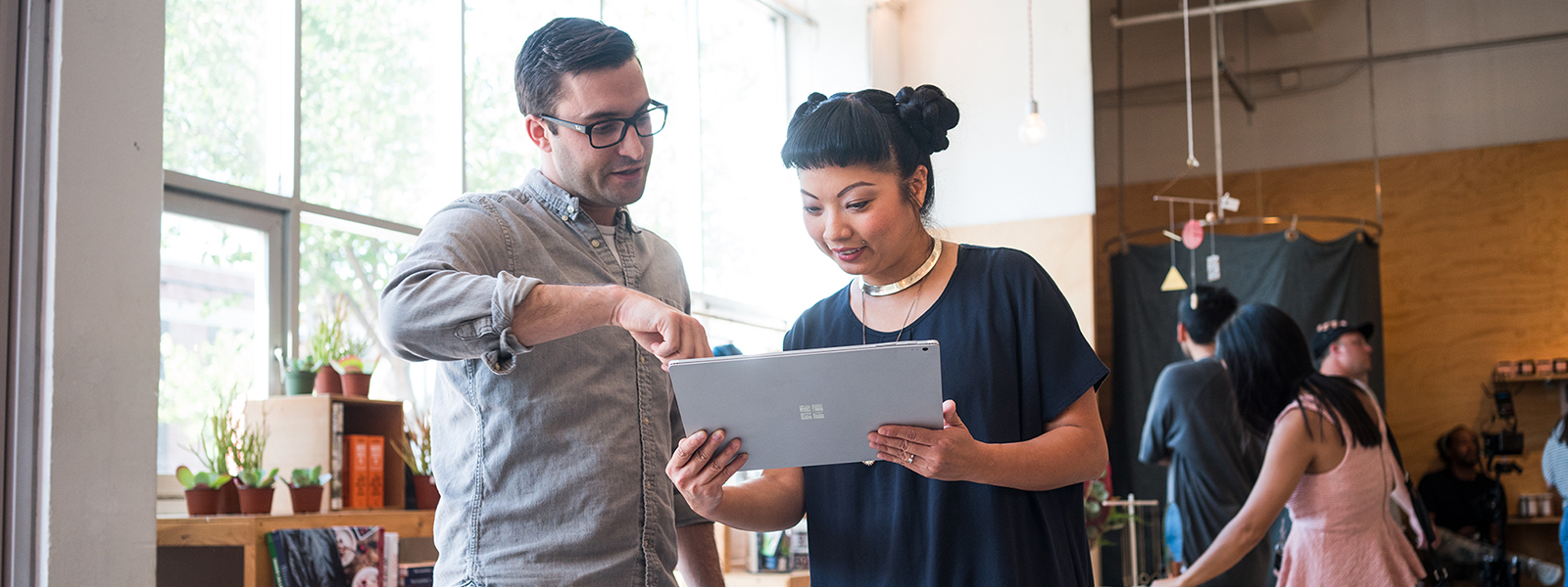 Image of two firstline workers collaborating over a laptop