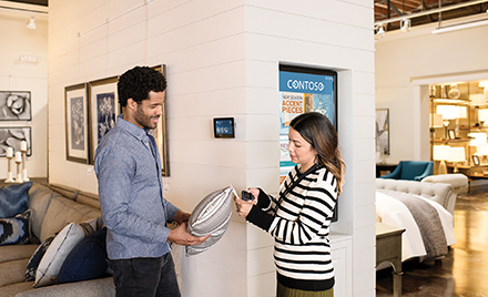 Two firstline workers examine a pillow in a shop