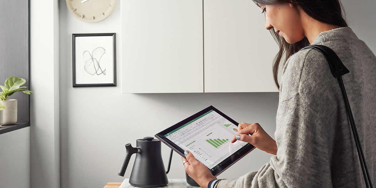 Image of a woman looking at an Excel graph on her tablet