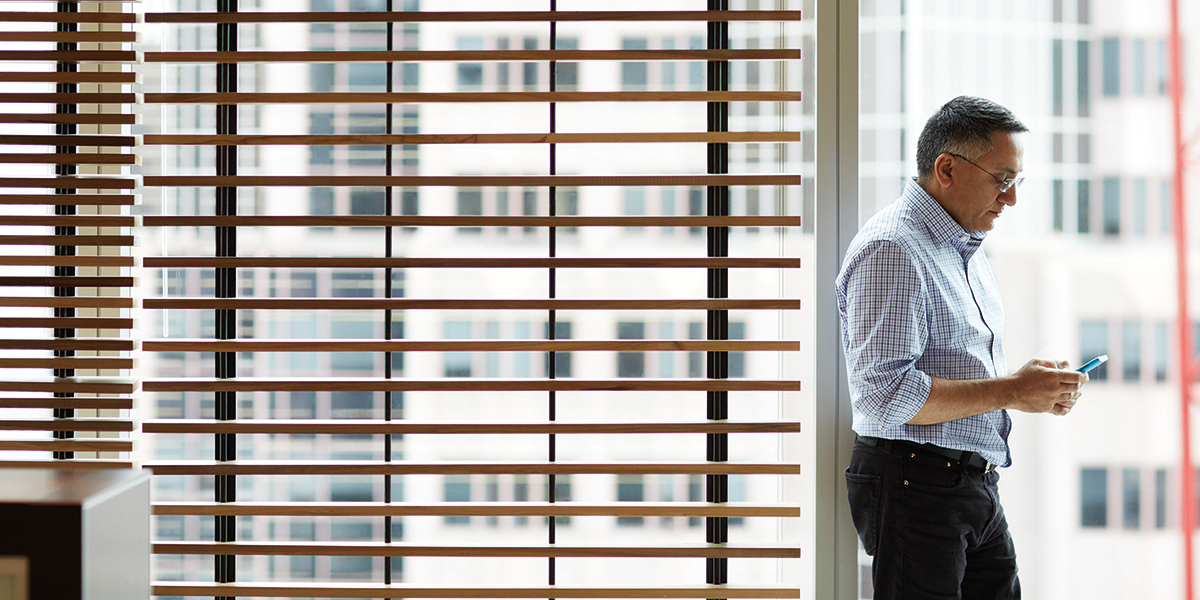 Image of a man in an office looking at his phone