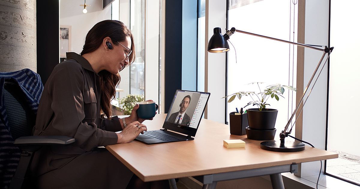 Image of a worker in a Teams conference at her desk