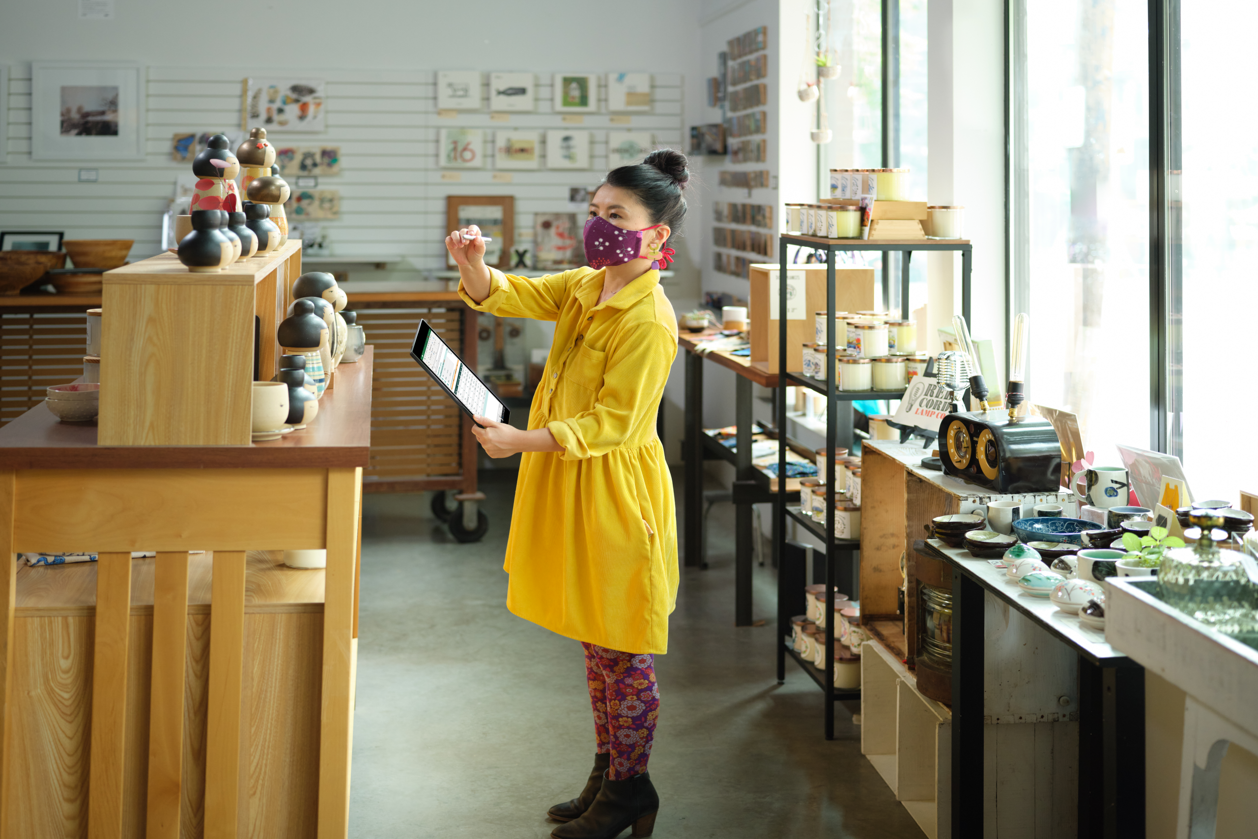 Retail employee with mask reviewing inventory for a curbside pickup order in Excel on OneDrive