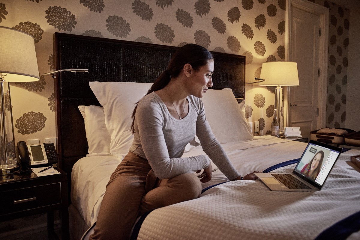 Female small business professional using Microsoft Teams in a hotel room