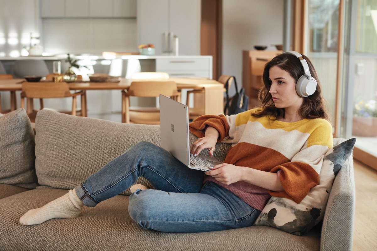 Female student with Surface Book 2 and Surface Headphones at home works remotely or attends Teams meeting