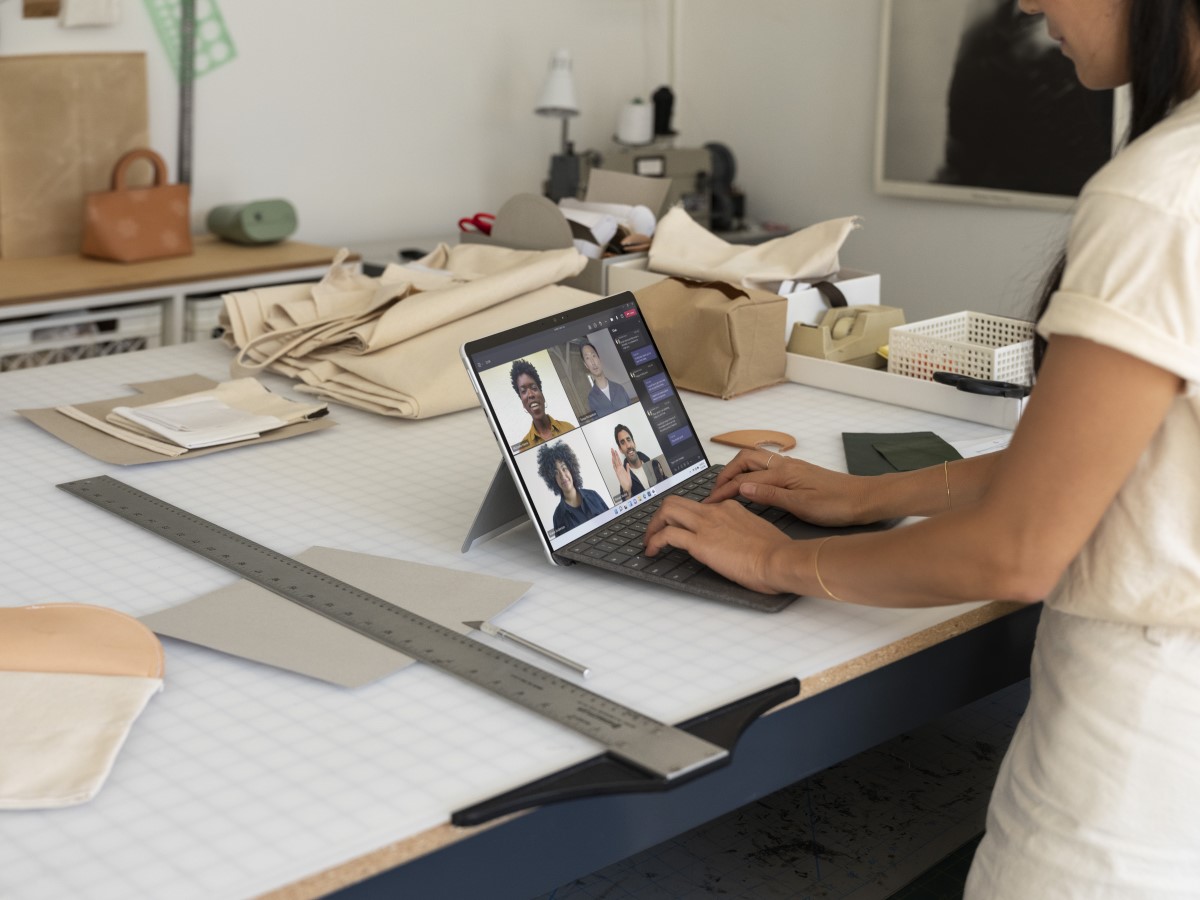 Contextual photography of adult female inside using Surface Pro X to participate in Microsoft Teams call